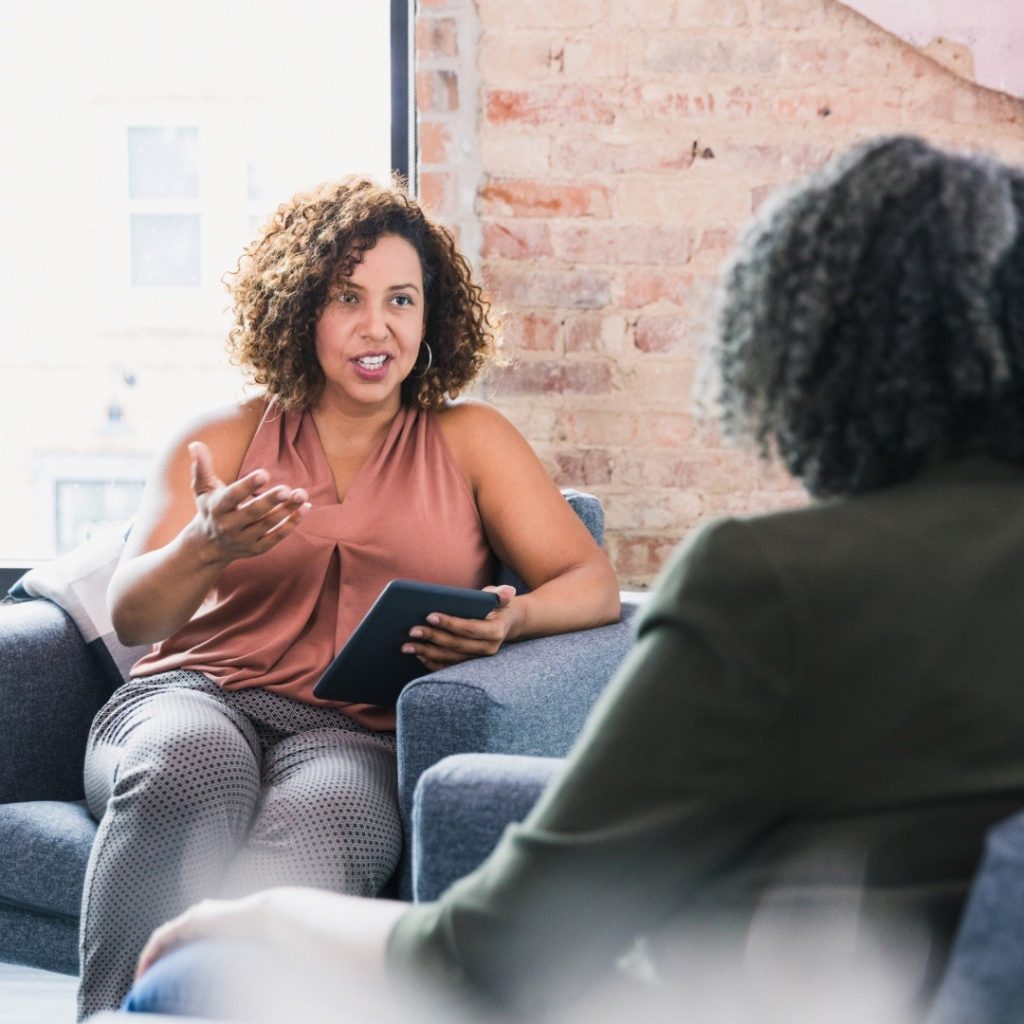 Two women conversing in a cozy, modern room.