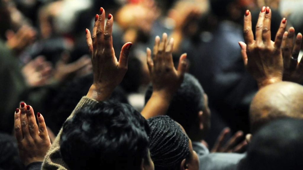 Hands raised in a crowd.