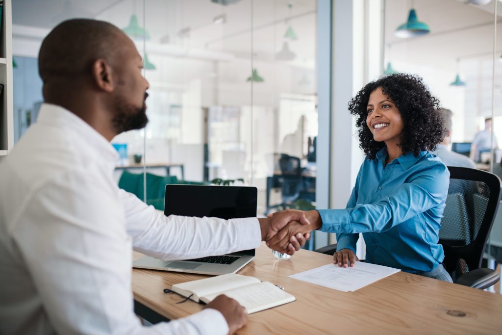 Man and woman shaking hands in an office.
